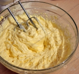 Продолжаем готовить крем. Отдельно взбейте сливочное масло и потихоньку введите его в крем, продолжая постоянно взбивать. Коржи сложите стопкой и обрежьте лишние края, чтобы получились ровные одинаковые прямоугольники.