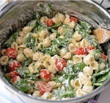 Готовую пасту промойте, хорошенько отцедите и, пока кастрюля еще горячая, выложите в нее пасту, томаты, шпинат и кремовый соус. Хорошенько все перемешайте.