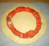 Для начала разведите дрожжи в теплом молоке, затем добавьте туда сахар, масло, соль и яйцо. После добавления каждого ингредиента хорошенько перемешивайте. Добавьте муку и замесите тесто. Укройте тесто и уберите в холодильник на 3 часа минимум.
Когда тесто подойдет (оно увеличится раза в два), достаньте его из холодильника и оставьте при комнатной температуре еще на час. Когда пройдет время, раскатайте тесто вкруг так, чтобы толщина теста была около 0,6 см. Нарежьте форель на кусочки примерно 2,5 см, а затем выложите их по кругу на тесто, отступив от края 3,5 см. Накройте тестом, которое осталось по краям и хорошенько защипите.