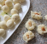 Теперь начинаем лепить конфеты. Чайной ложкой возьмите немножко кокосовой массы, в серединку вложите миндальный орешек, а затем влажными руками скатайте шарик (он должен быть размером примерно с грецкий орех).
Готовые конфеты поставьте в холодильник минут на 30, а перед подачей обрызните их водой и обваляйте в кокосовой стружке.
Приятного чаепития!