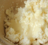 В кокосовую стружку влейте сгущенку и хорошенько перемешайте до однородного состояния. Оставьте постоять минут на 15.