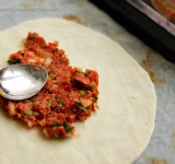 Замесите густое тесто. Разделите его на 6 равных частей. Раскатайте из одной части круглую лепешку. На лепешку выложите 1/6 часть фарша и равномерно размажьте по тесту.
Разогрейте духовку. Выстелите противень пергаментом, выложите на него лепешку и выпекайте до румяных краешков (около 10 минут). Можно посыпать лучком.