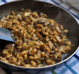 Тем временем готовим начинку. Разогрейте сковородку с маслом. Измельчите лук и слегка обжарьте его. Грибы нарежьте на мелкие кусочки и добавьте к луку. Посолите, поперчите и перемешайте. Жарьте все минут 15, пока полностью не испарится жидкость. Натрите сыр на мелкой терке.