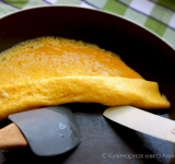 Вооружившись лопаткой, ухватитесь за самый побелевший краешек омлета и аккуратно сверните рулетик. Внимание, ждать, пока верх омлета пропечется не нужно! Сворачивайте омлет тогда, когда серединка еще не прожарилась. Пока вы будете сворачивать рулет, он успеет пропечься. 
 
Подавайте такой омлет горячим. Приятного аппетита! 
 
Ссылка на источник рецепта:  kulinariya123.blogspot.ru/2013/10/618_26.html 	