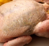 На куриной грудке аккуратно приподнимите кожицу и в кармашек, который получится, вложите фарш. Утрамбовать нужно достаточно плотно, но так, чтобы кожа не разорвалась. Внутрь курицы вложите половинку лимона, с которого вы снимали цедру. Ножки курицы свяжите вместе.
Куриную тушку смажьте тоненьким слоем горчицы и посолите по вкусу. Разогрейте духовку.