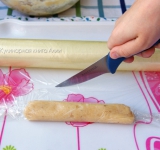 Немного раскатайте пищевую пленку и выложите на нее 2 ст. ложки фарша, закрутите и слегка утрамбуйте. Отрежьте пленку. В разные стороны скрутите сосиску на подобие фантика конфеты, свяжите кончики.