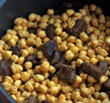 Для начала нужно на сутки замочить нут, чтобы он увеличился в два раза. Потом промыть его чистой холодной водой.
В казане растопите масло. Нарежьте мясо на небольшие кубики и обжарьте в казане до румяной корочки, до поджаристого коричневого цвета. Залейте помидоры кипятком.
К мясу выложите нут и готовьте, пока не выпарится вся влага. Когда мясо с нутом начнут поджариваться, готовьте минут 5.