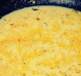 Для начала в миску разбейте яйца, добавьте молоко и хорошенько взбейте венчиком до однородности. Добавьте измельченный бульонный кубик по вкусу. Я люблю соленое, поэтому добавлял 1/4 кубика, но тут все дело вкуса.
На сковородке растопите сливочное масло и хорошо прогрейте. Тщательно перемешайте яичную смесь с приправой так, чтобы она равномерно распределилась по смеси. Вылейте будущий омлет на сковородку.